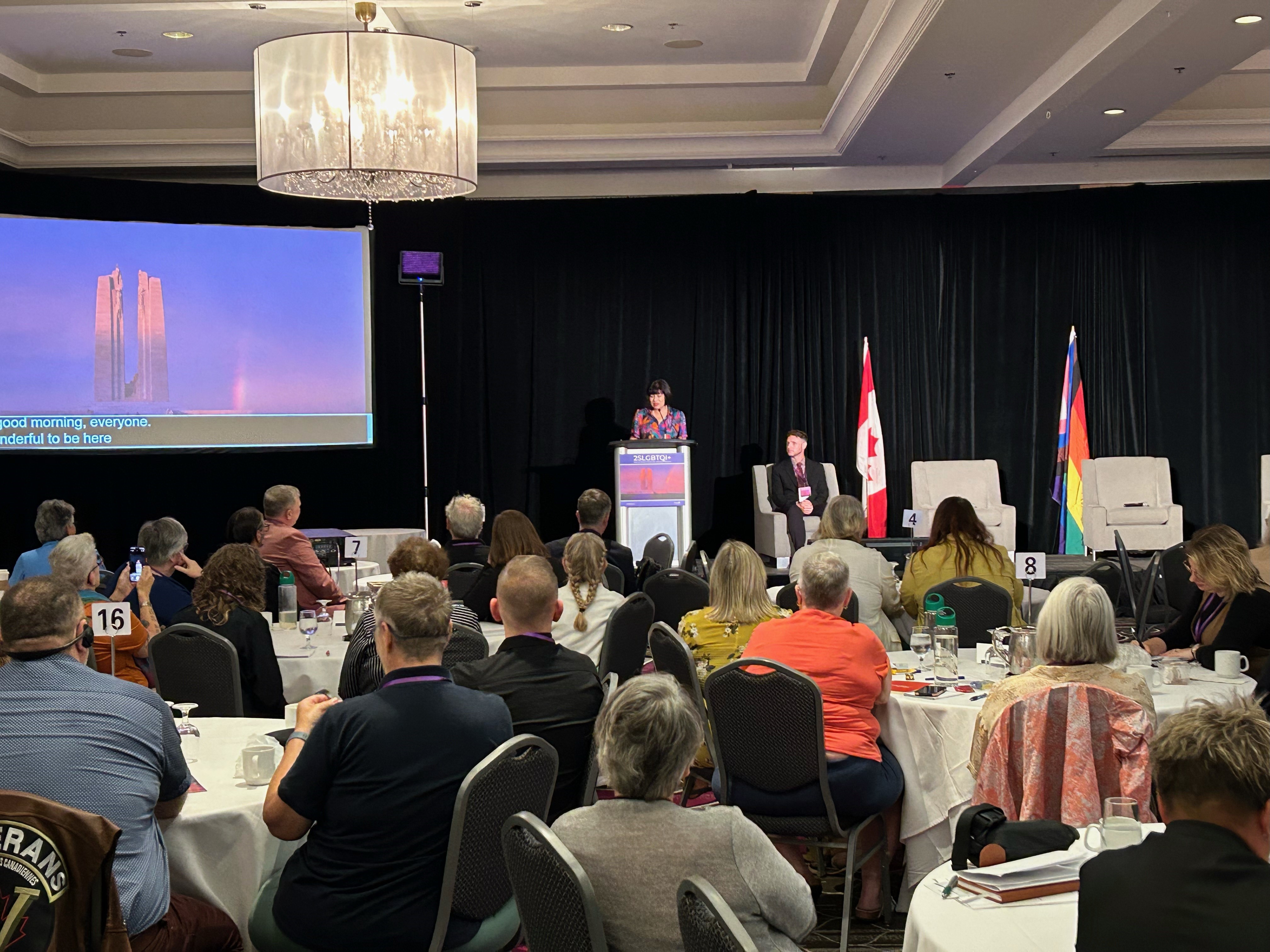Former Minister of Veterans Affairs, Ginette Petitpas-Taylor, speaking in front of a crowd at the 2024 2SLGBTQI+ Veterans Forum.