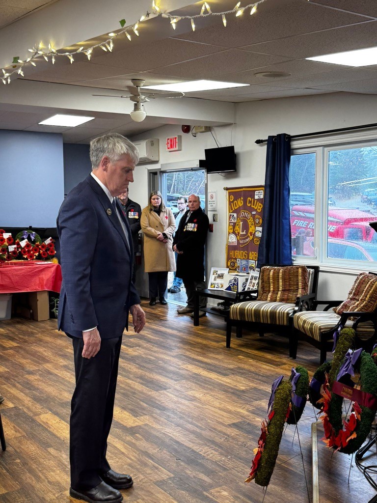 Board Chairperson Christopher J. McNeil standing in a moment of silence after laying a wreath at a 2024 Remembrance Day ceremony.